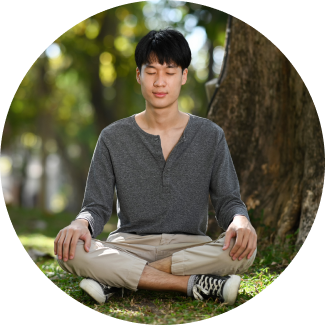 Woman sitting on beach side with hand on heart focusing on breath